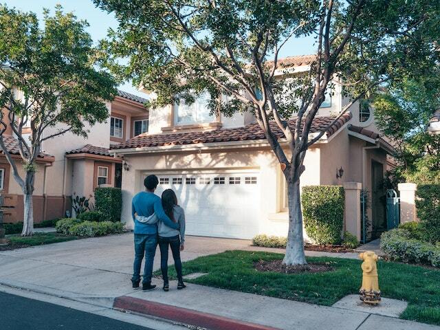Couple standing in front of two properties